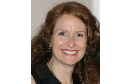 Sourire chaleureux d'une femme lors d'un événement choral.