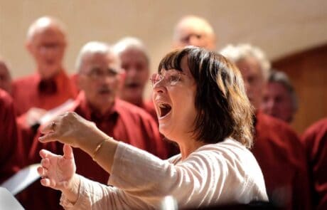 Chef de chœur dynamique dirige un groupe de choristes lors d'une répétition passionnée. Choeur d'hommes de Vannes