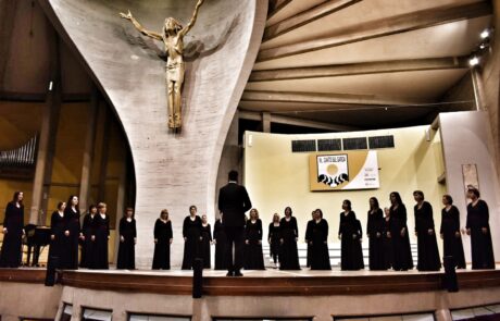 Chœur de femmes en concert dans une salle de spectacle élégante.